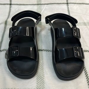 Women’s Gucci sandals, black plastic.